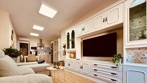 A modern living room with a sofa, TV, and cabinets.