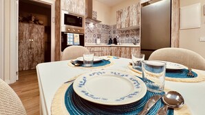 A dining area with a table set for four, including plates, glasses, cutlery, and a placemat.