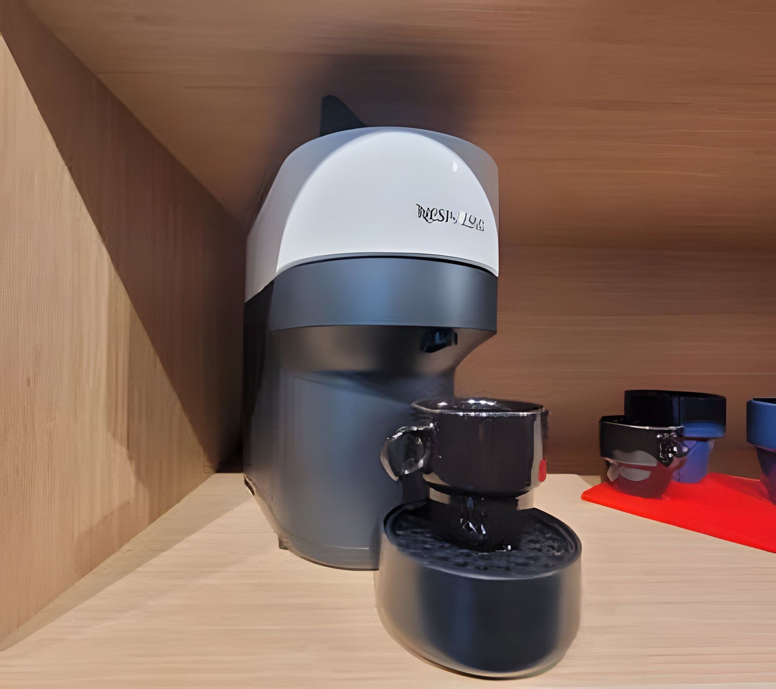 A coffee machine with a cup attached, placed in a wooden cabinet.