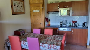 A compact kitchen with wooden cabinets, a microwave, a coffee maker, and a toaster.