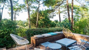 Una terraza exterior con asientos, una mesa y un banco de madera.