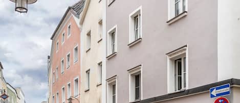 Une vue de rue avec des bâtiments, un lampadaire et des panneaux de signalisation.