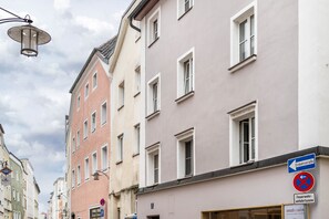 A street view with buildings, a street lamp, and directional signs. - The Cozy Corner – Passau (Passau)