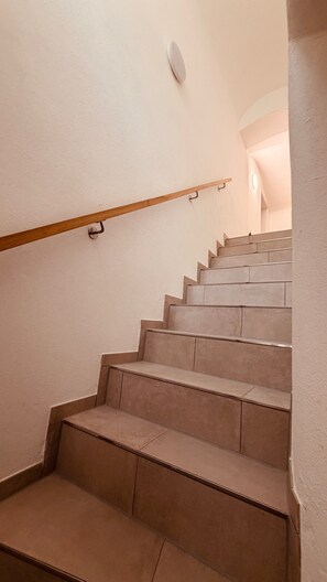 A staircase with a wooden handrail and beige steps. - The Cozy Corner – Passau (Passau)