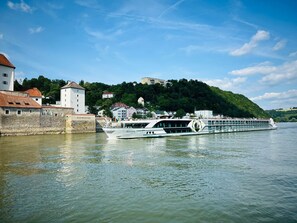 A river with a large white boat named 'SAVOR' docked at a stone pier. - The Cozy Corner – Passau (Passau)