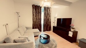 A modern living room with a sofa, coffee table, TV, and curtains. - Cozy Corner – Passau (Passau)