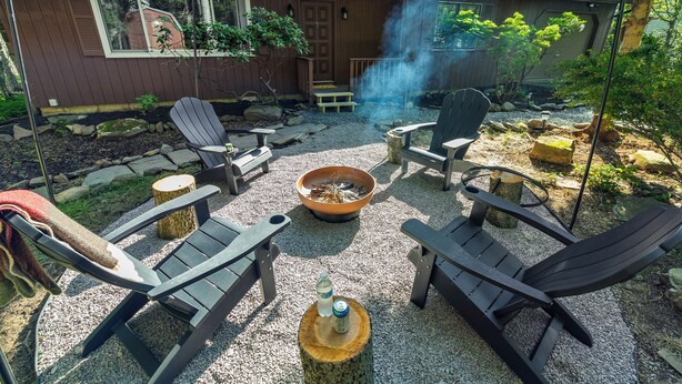 A backyard with a fire pit, outdoor seating, and a house with a chimney. - Access to PGA Golf Course- Private Hot Tub-Firepit (Tobyhanna)