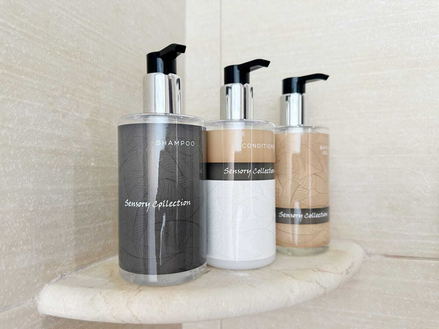 Three bottles of Sensory Collection on a marble shelf.