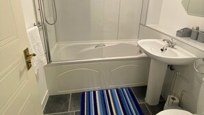 A bathroom with a bathtub, a sink, and a toilet.