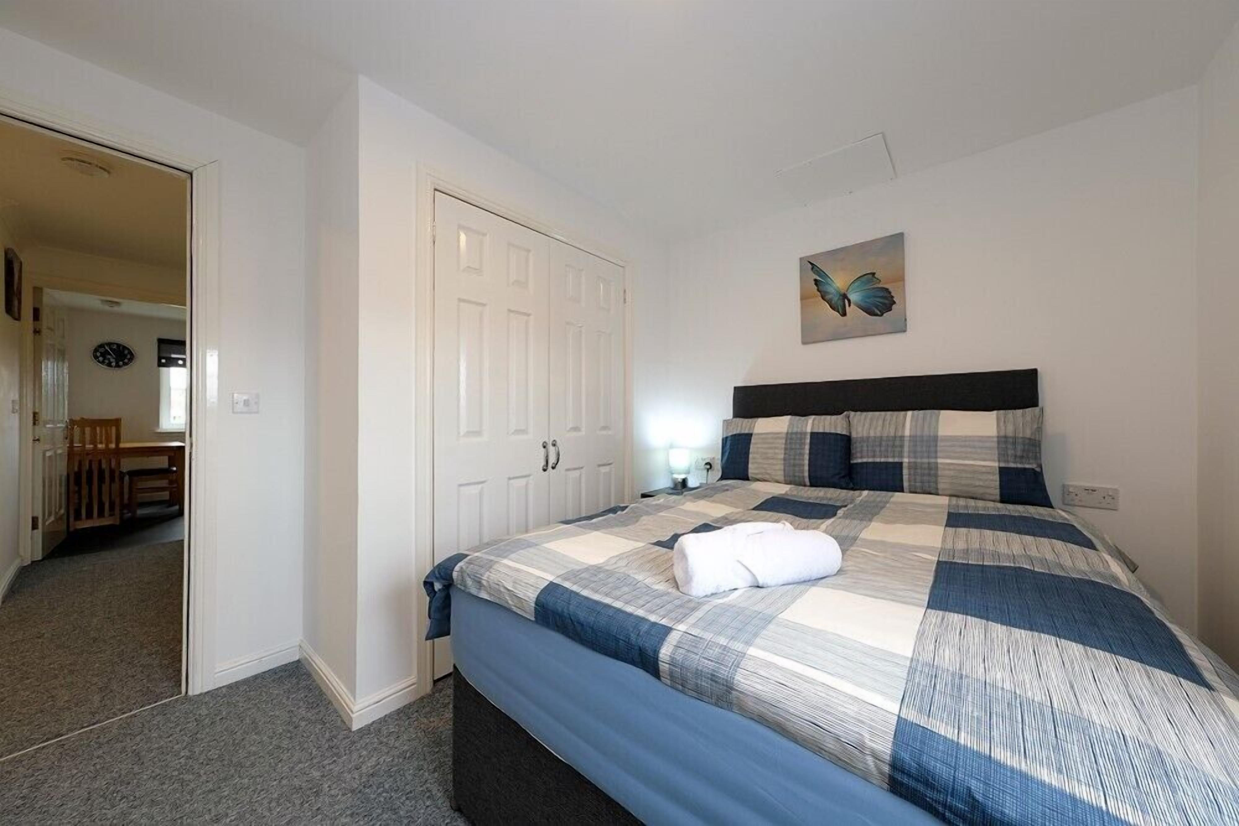 Ein Schlafzimmer mit einem Bett, einem Kleiderschrank und einem Bild an der Wand.