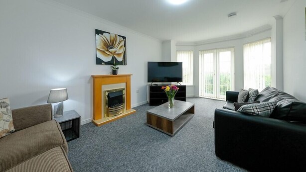 Una sala de estar con chimenea, televisor, sofá y una mesa de centro.