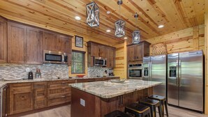 Una cocina moderna con armarios de madera, electrodomésticos de acero inoxidable y encimera de granito.