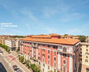 Un edificio rosso con tetto in tegole, con la scritta Basilica di San Giovanni in Laterano.