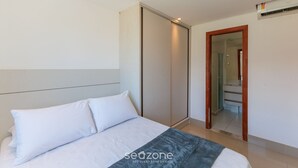 Ett hotellrum med en säng, en garderob och ett badrum som syns genom en öppen dörr.