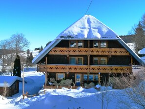 Un edificio in stile chalet con tetto spiovente, numerose finestre e un balcone in legno.