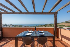 Eine hölzerne Pergola mit Tisch für zwei Personen, mit Blick auf eine reizvolle Landschaft.