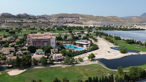 Un resort con varias edificaciones, una piscina grande y un campo de golf.