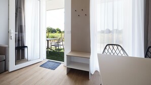 A modern room with a sliding glass door leading to a balcony, a small table, and a chair.