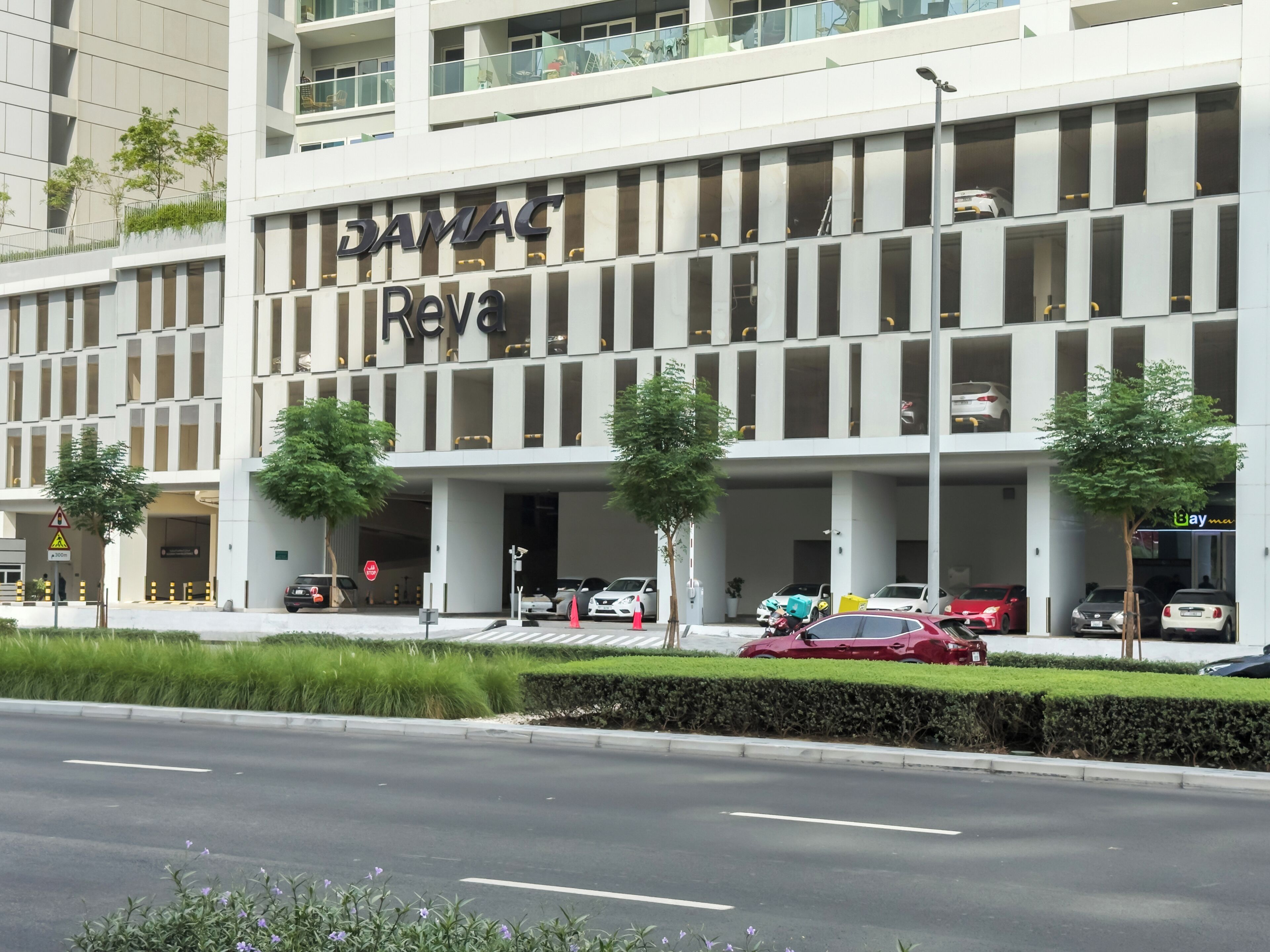 A modern building with a sign reading "DAMAC Reva".