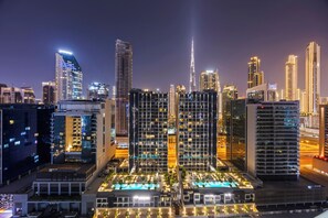 Un hôtel moderne composé de plusieurs immeubles de grande hauteur, d’une tour imposante et d’un espace piscine bien éclairé.