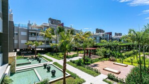 A rooftop garden with a swimming pool, palm trees, and a pergola. - Apartment in Thai Beach Home Spa Tbs1105 (Florianópolis)