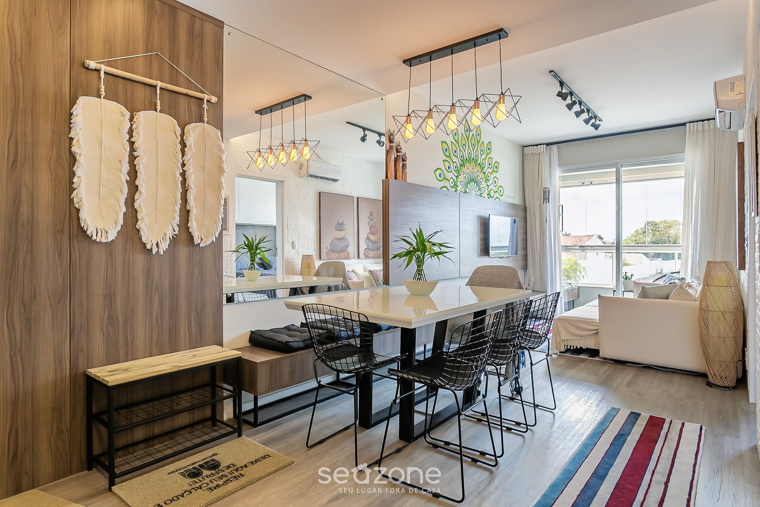 Una sala de estar moderna con un ventanal grande, un sofá, una mesa de centro y un comedor con sillas y una mesa.