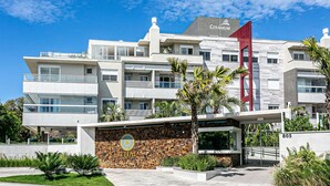 A modern hotel with a Ceranium sign, multiple balconies, and a stone wall entrance. - Apart in Thai Beach Home Spa Cond sea Front Tbs106 (Florianópolis)