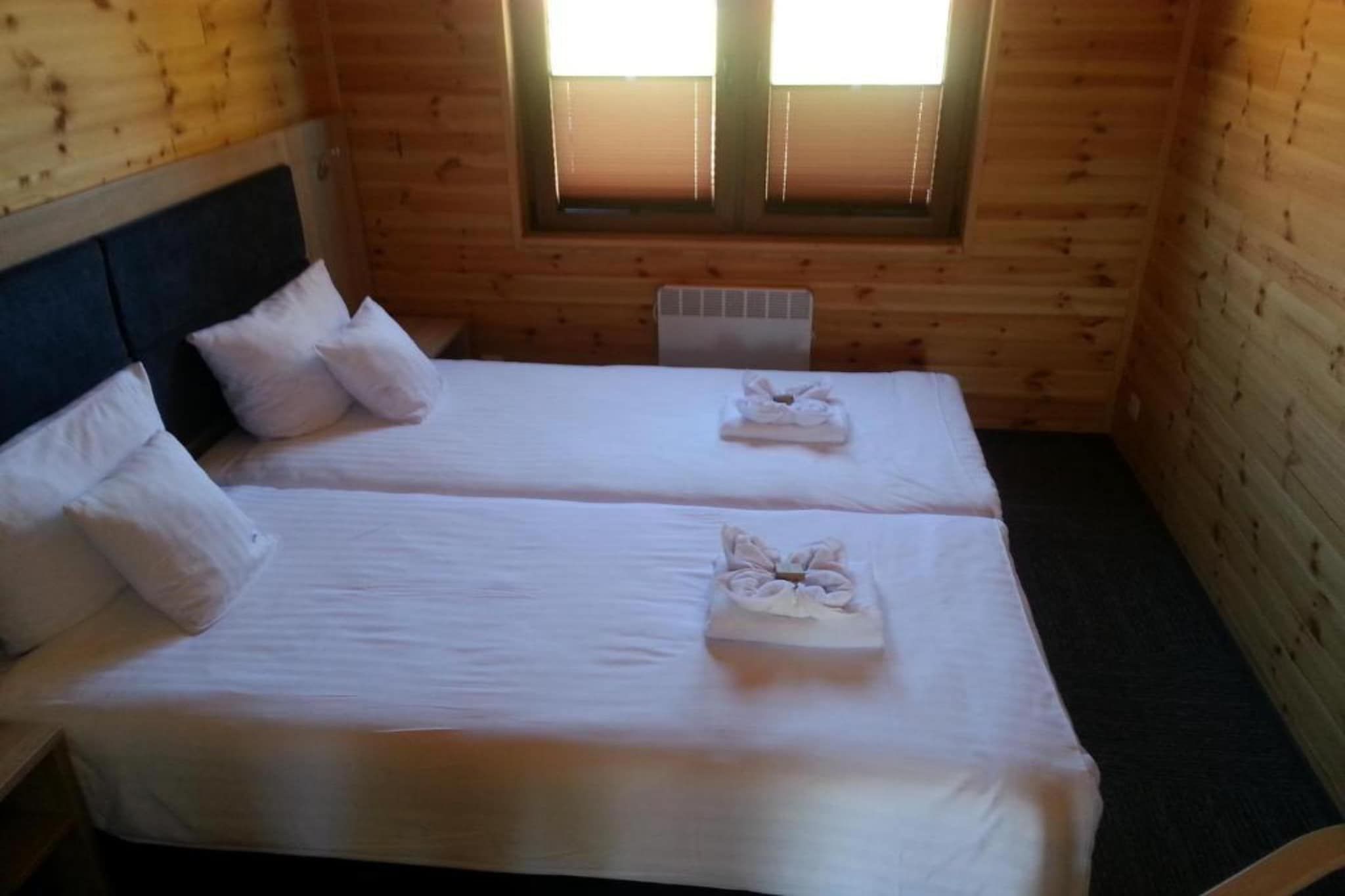 Una habitación con dos camas, una ventana y un radiador.