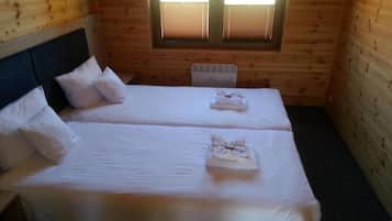 Una habitación con dos camas, una ventana y un radiador.