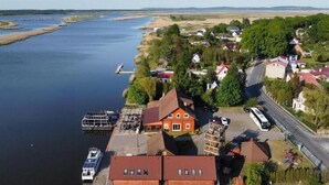 An aerial view of a riverside town with houses, a dock, and a boat. - Double room with breakfast in Świnoujście (Świnoujście)