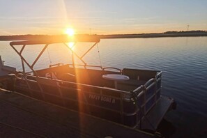 A boat docked at a pier with a clear view of the sunset over the water. - Double room with breakfast in Świnoujście (Świnoujście)