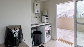 A compact laundry room with a washing machine, dryer, and a water heater.