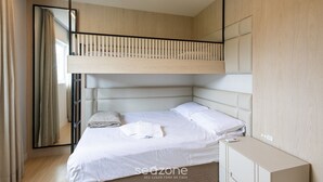 A modern bedroom with a bunk bed, a bedside cabinet, and a large mirror. - Modern 2BR Apt Close to the Beach Stl0702 (Balneário Camboriú)