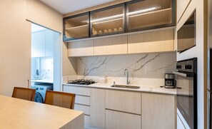 Una cocina moderna con encimera de mármol, electrodomésticos de acero inoxidable y armarios de madera.