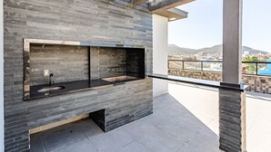 A modern outdoor kitchen with a stone backsplash and a sink. - Studio in Condominium With Pool 700m Beach Sti210 (Florianópolis)