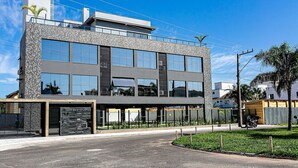 A modern building with a glass facade, large windows, and a flat roof.