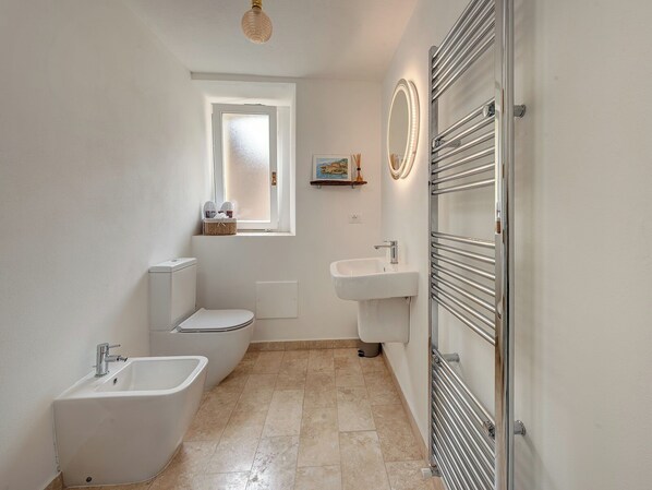 A bathroom with a toilet, bidet, sink, and a mirror with lights. - La Casa Della Seta (Tremezzo)