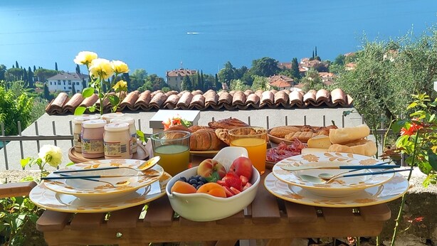 A breakfast table with a view of a lake and mountains. - La Casa Della Seta  (Tremezzo)