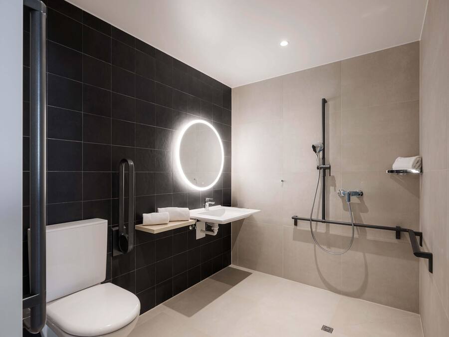 Ein modernes Badezimmer mit Toilette, Waschbecken und Dusche.