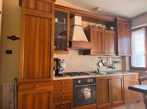 A kitchen with wooden cabinets, a stove, and a sink.