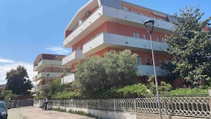 A multi-story residential building with balconies, a gated entrance, and a street lamp. - Apartment 'Teresa Al Mare' with Balcony, Wi-Fi and Air Conditioning (Montesilvano)
