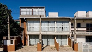 A two-story building with a flat roof, large windows, and a gated entrance. - 2BR Apt w/ BBQ 600m From the Sea Rvl118 (Bombinhas)