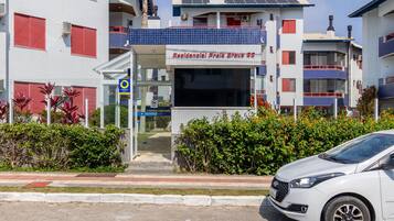 A residential building with a sign reading "Residencial Praia Brava 96".