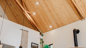 A high ceiling with wooden beams and recessed lighting.
