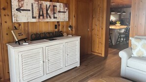 Un intérieur rustique en bois, avec une enseigne indiquant « LAC » au-dessus du bar.