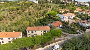 A residential area with houses, a road, and a white truck. - Apartment 'Unique in Rosignano' with Balcony, Wi-Fi and Air Conditioning (Rosignano Marittimo)