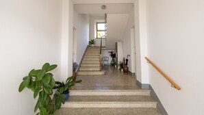 A staircase with a handrail, potted plants, and a chair. - Apartment 'Unique in Rosignano' with Balcony, Wi-Fi and Air Conditioning (Rosignano Marittimo)