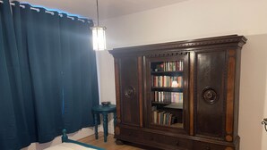 Une chambre à coucher avec un lit, une armoire en bois, une petite table et une lampe.