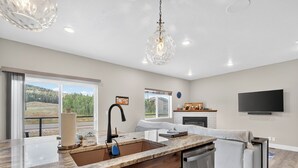 A modern kitchen with a large island, a dishwasher, and a dining area with a sofa. - Spacious Pet Friendly Mountain Townhome | Game Room + Near Slopes (Brian Head)