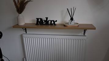 A shelf with decorative items and a radiator below.